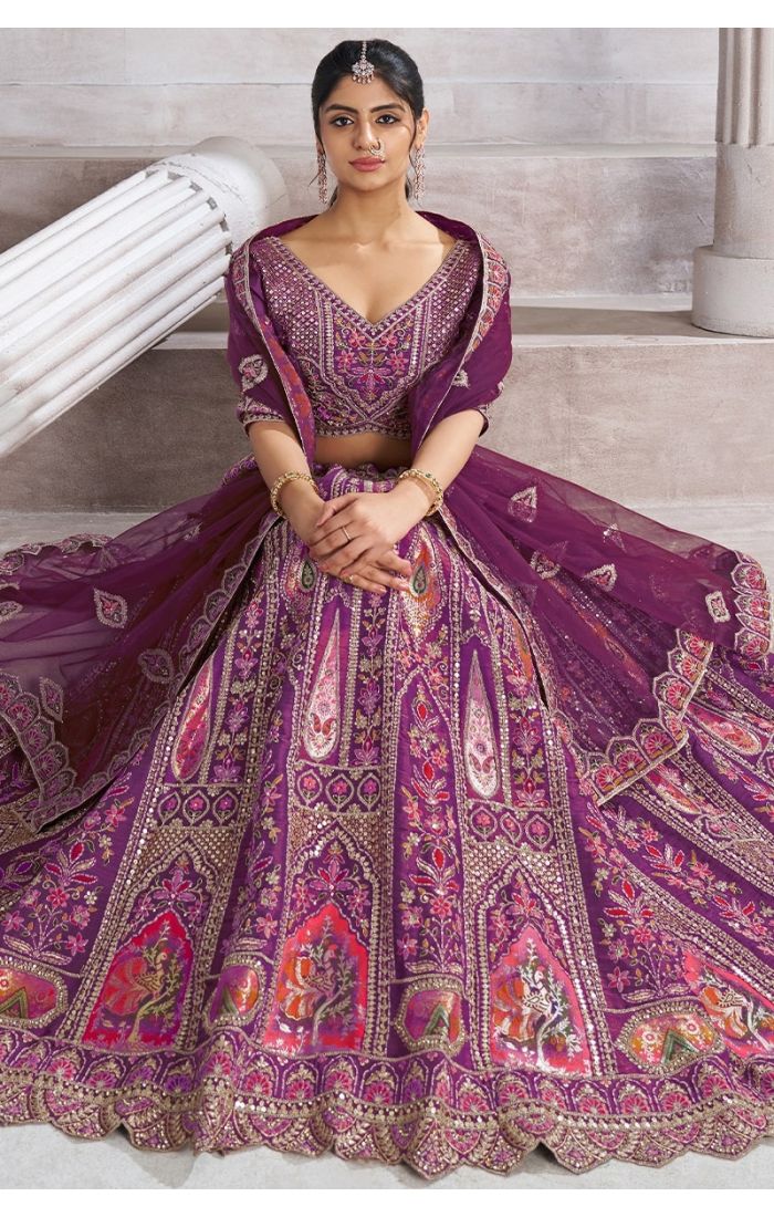 Sitting pose in Berry Purple bridesmaid lehenga with vibrant bird motifs and heavy flare – Appelle Fashion