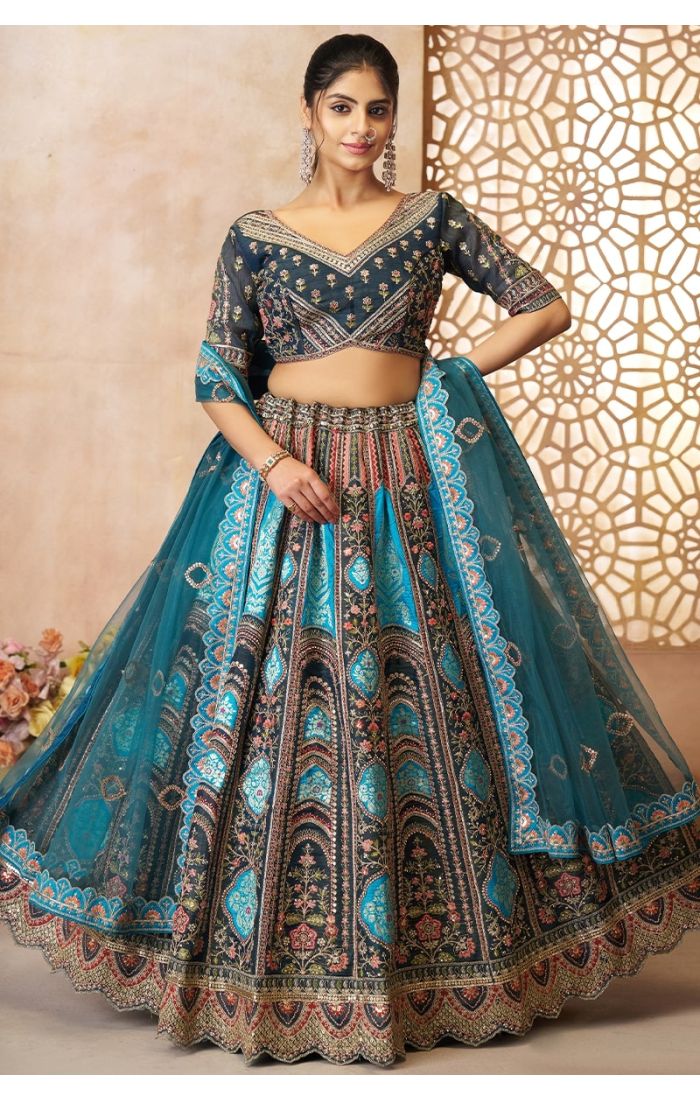 Front standing pose of model in blue embroidered bridal lehenga with dupatta