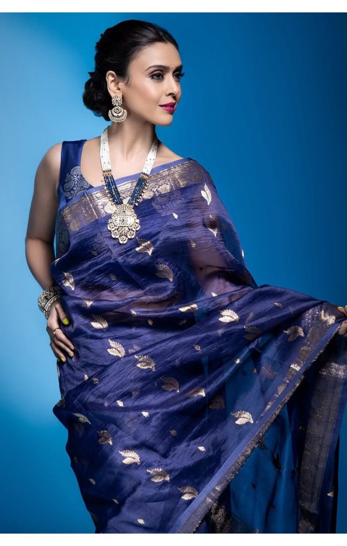 Close-up of blue silk saree with zari leaves and golden border – elegant detailing.
