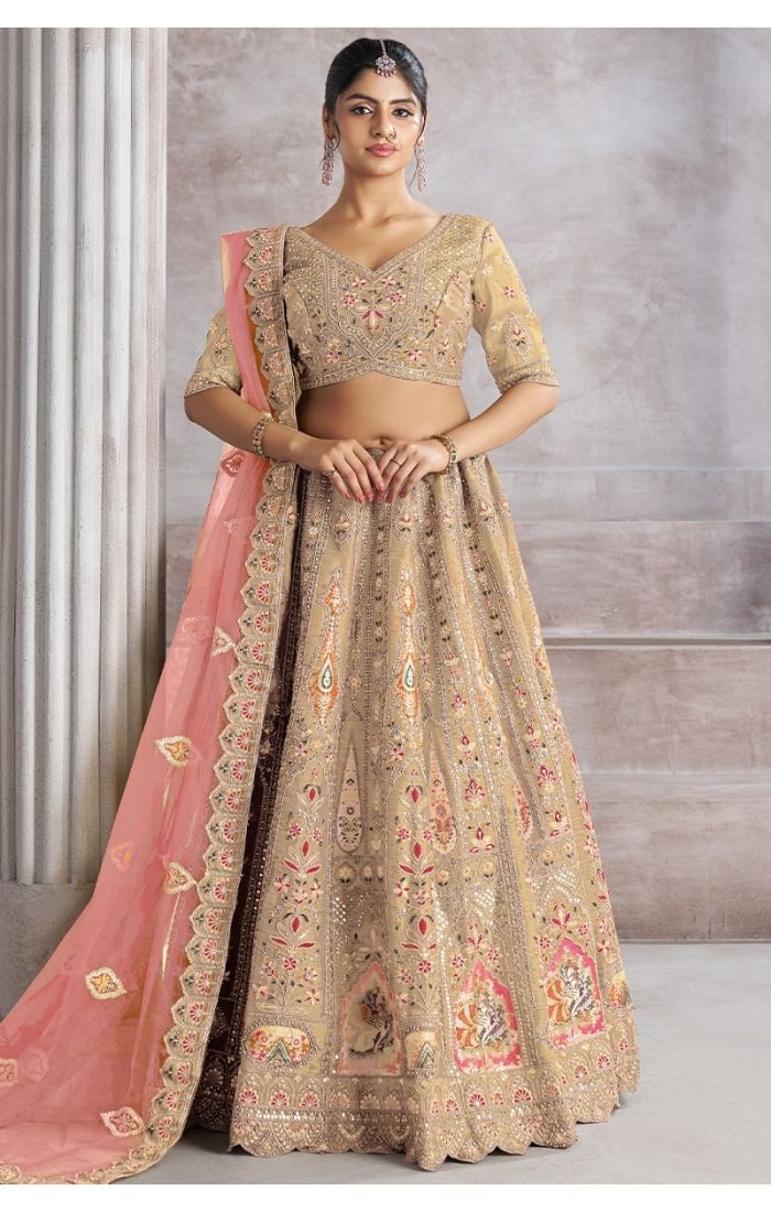 Front view of champagne bridal lehenga with bird motifs and embroidered mocha blouse
