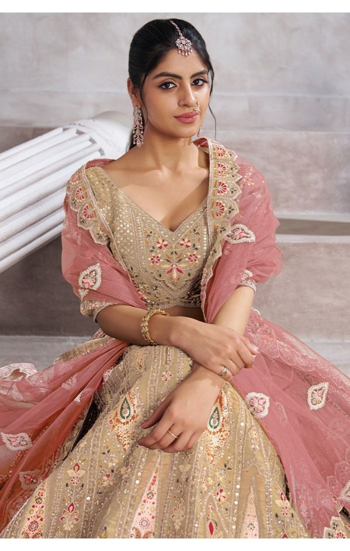 Close-up of bird motifs, sequins, and aari embroidery on champagne soft net lehenga
