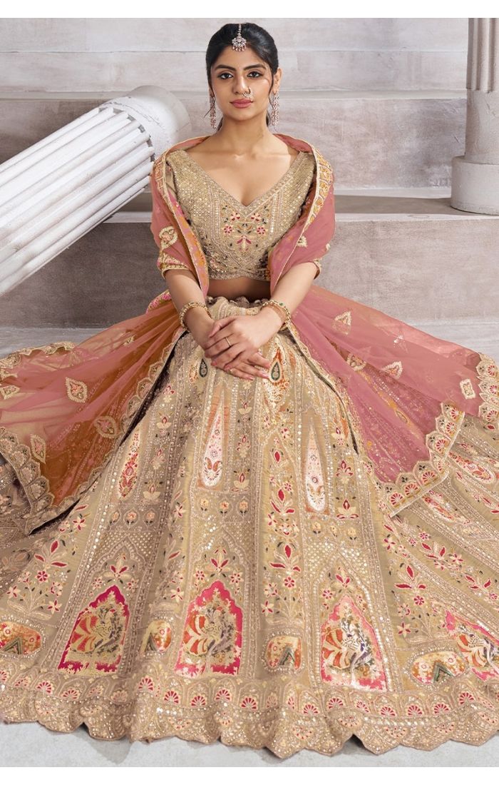  Bride sitting gracefully in aari patchwork lehenga with net dupatta