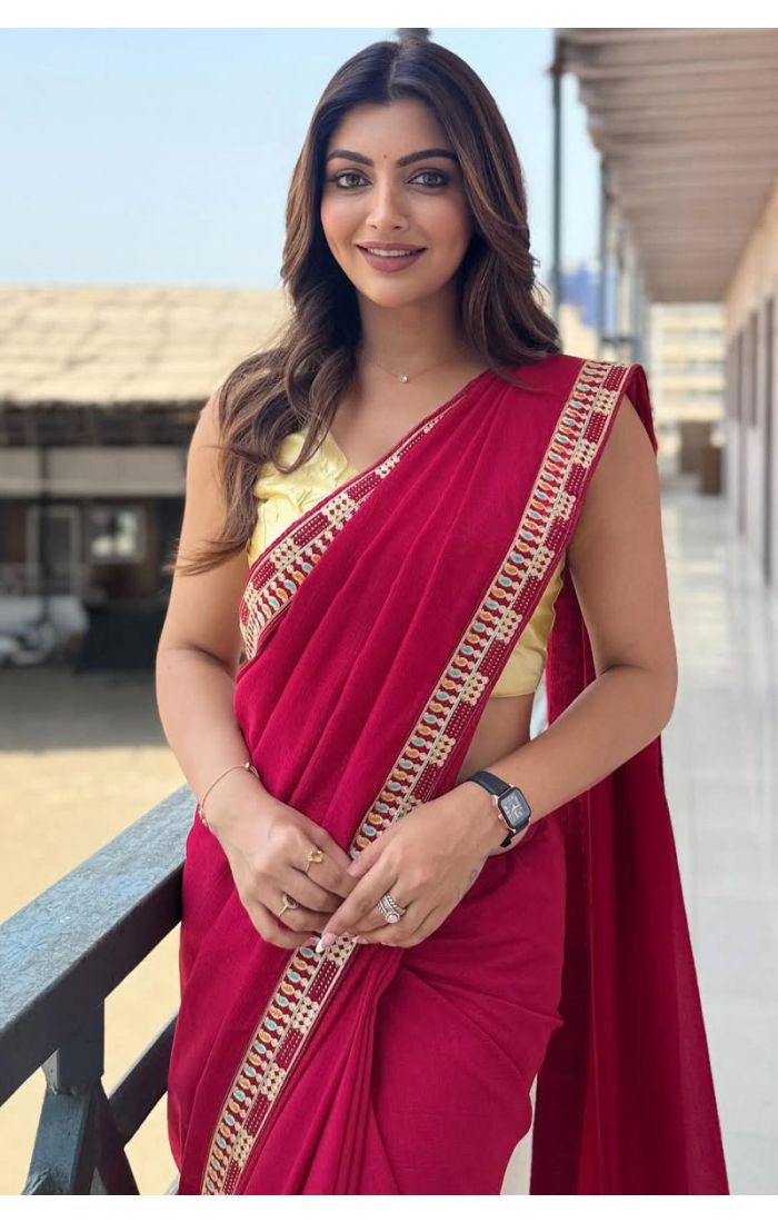Woman wearing a maroon cotton blend saree with thread work and tassel border, paired with a sleeveless yellow blouse – perfect for casual and festive occasions.