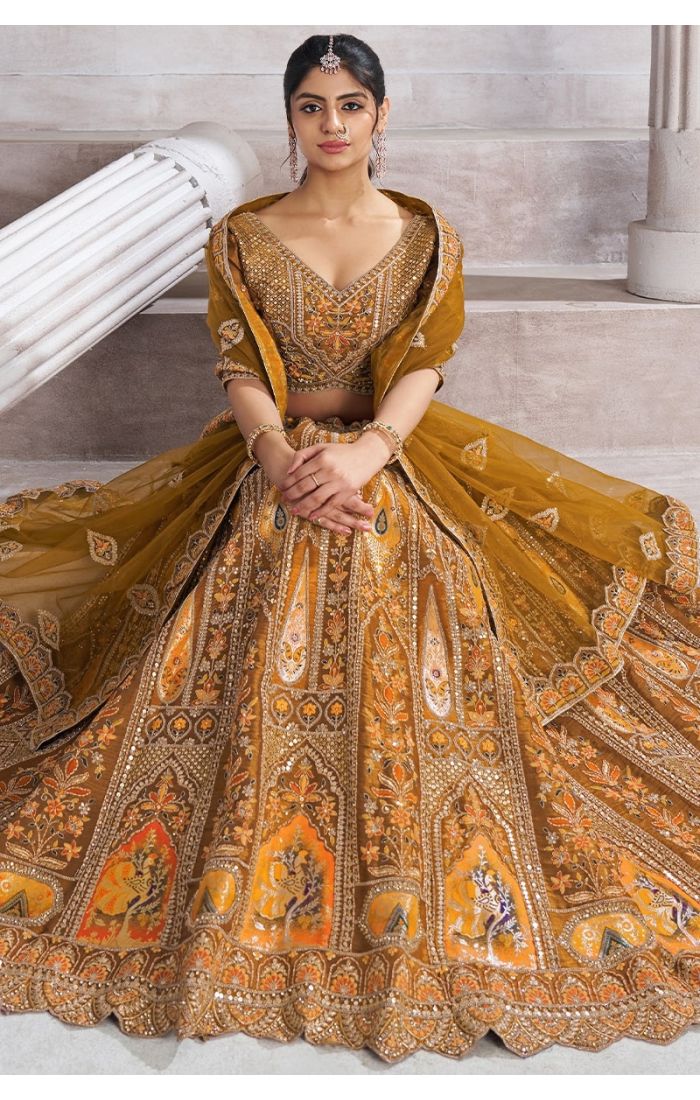 Seated pose in mustard bridal lehenga with mocha blouse and rich patch motifs – Appelle Fashion