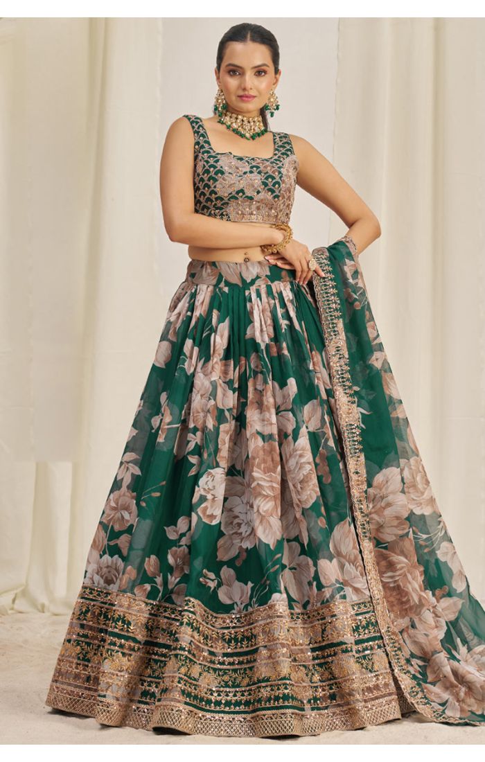 Model wearing emerald green floral net lehenga choli with embroidered blouse