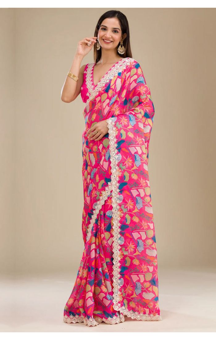 Floral print georgette saree with pink base and lace border for weddings and festive occasions.