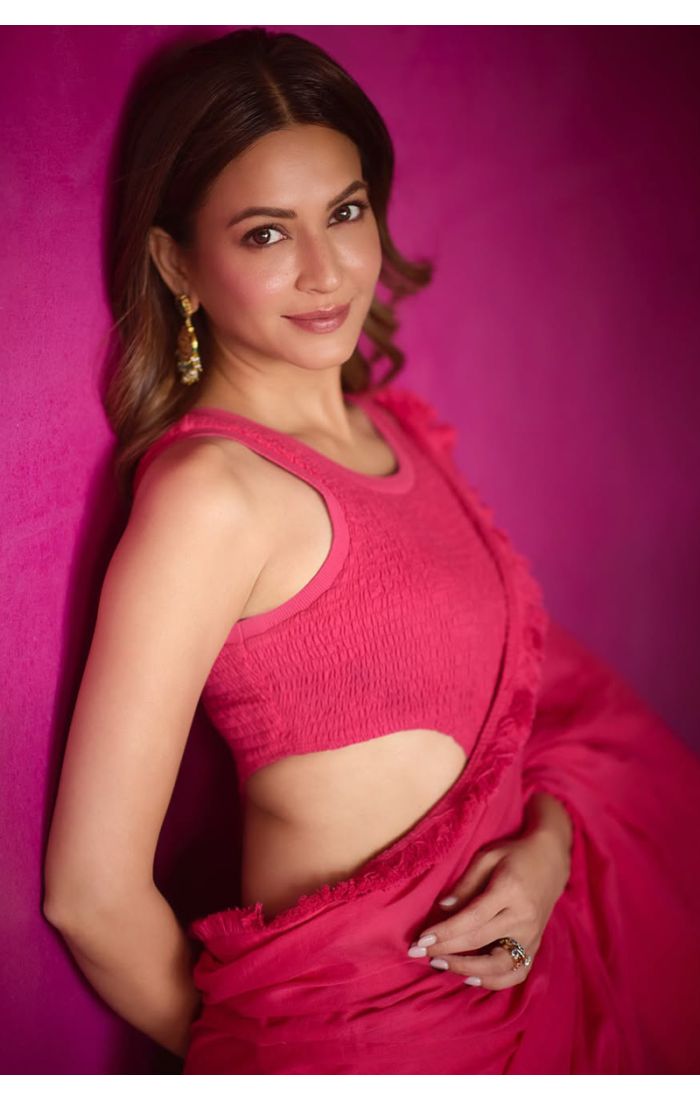 Woman in fuchsia sleeveless blouse styling a georgette saree