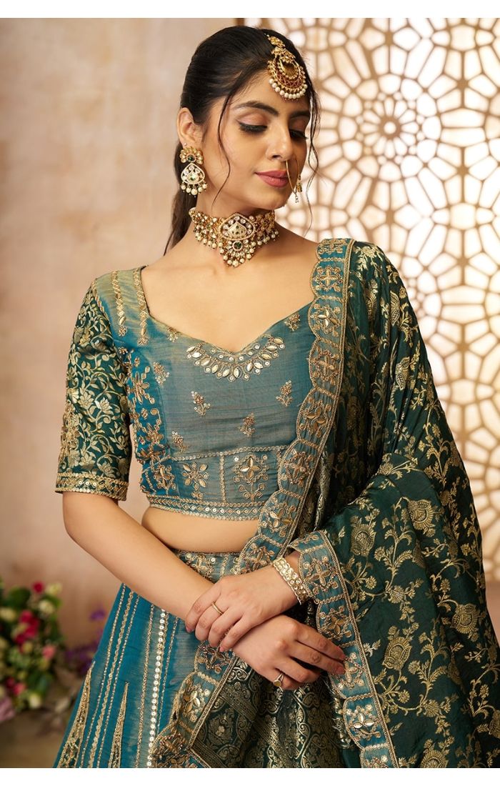 Close-up of blouse embroidery and Banarasi dupatta work on premium green bridal lehenga.