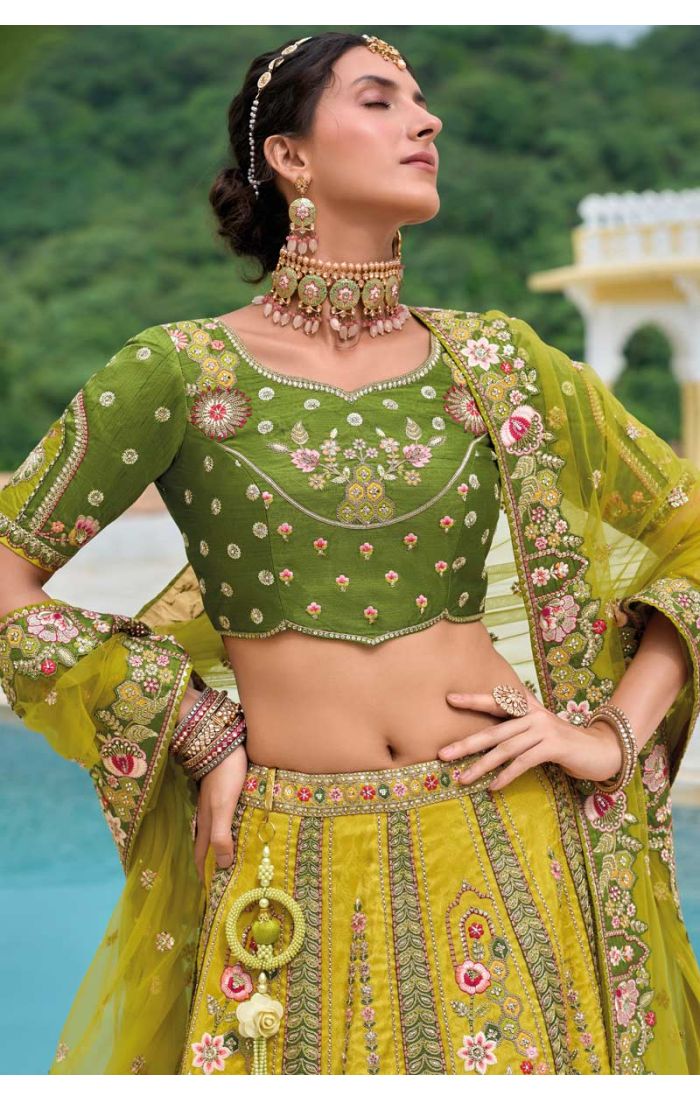 Model wearing a green floral embroidered lehenga choli, styled with traditional jewelry and light makeup, perfect for Haldi and festive occasions.