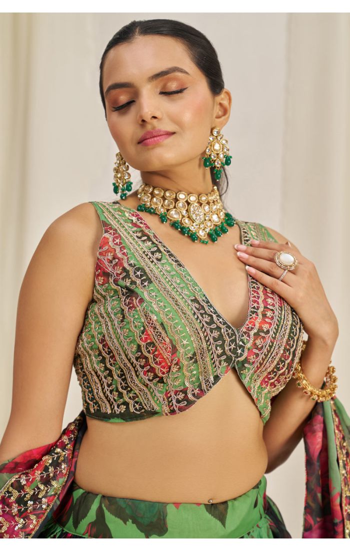 Close-up view of green floral embroidered V neck choli with intricate mirror and thread work