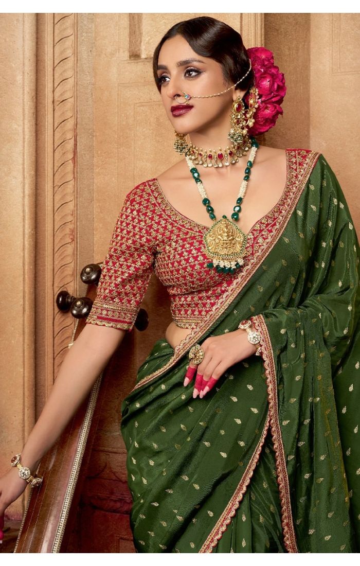 Close-up of zari and resham embroidery on green saree fabric