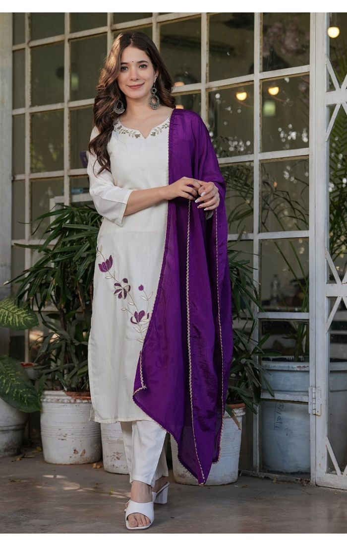 Off-white embroidered kurta pant set with a contrasting purple dupatta, perfect for festive and wedding occasions.