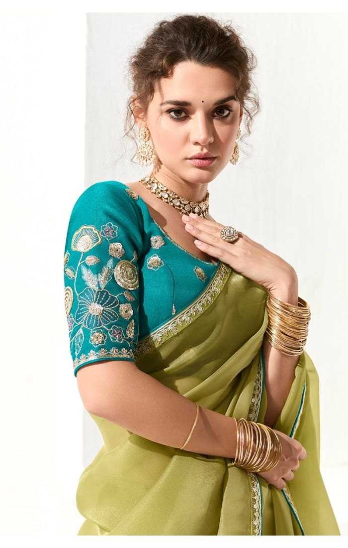 Detailed view of blouse embroidery and zari lace border of parrot green saree