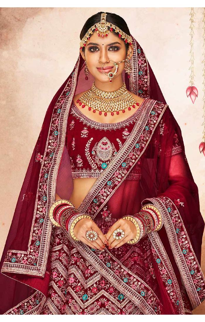 Close-up of maroon velvet bridal lehenga blouse with heavy zari, thread, and stone embroidery, luxury Indian bridal couture by Appelle Fashion.