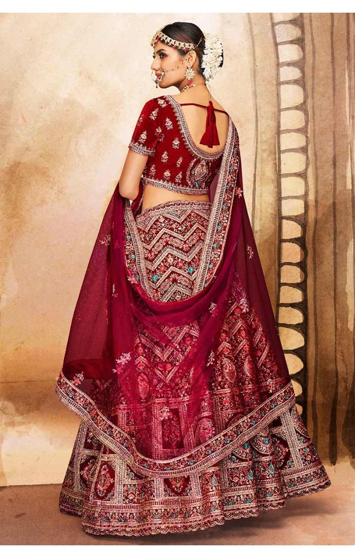 Detailed shot of maroon bridal lehenga blouse and richly embroidered dupatta with zari and stone work, premium bridal outfit.