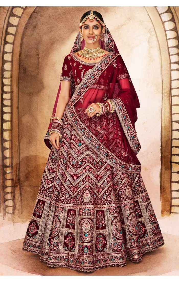 Full view of maroon heavy embroidered velvet bridal lehenga with ornate motifs and turquoise accents, royal Indian wedding wear.