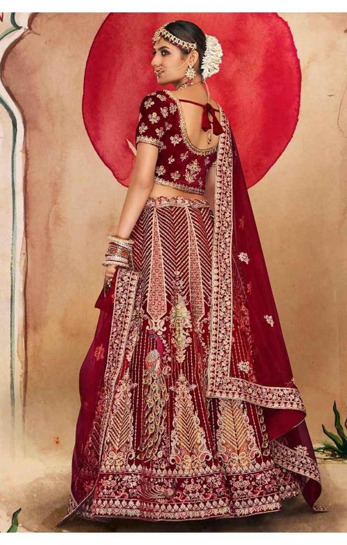 Detailed shot of maroon bridal blouse and embroidered dupatta with peacock and floral designs, premium Indian bridal fashion.