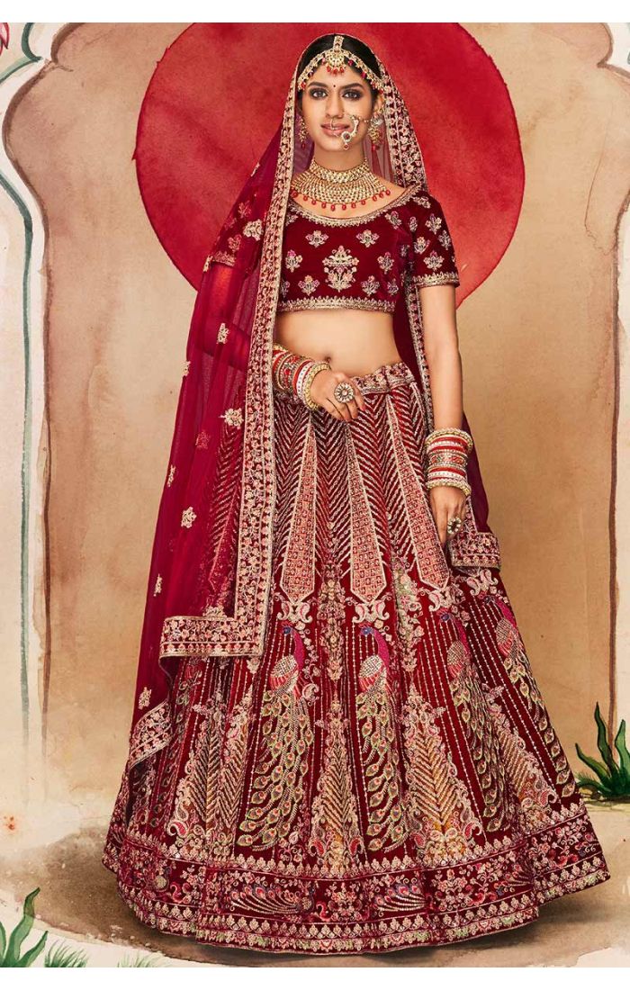 Full view of maroon velvet bridal lehenga with intricate peacock motifs and heavy zari work, royal wedding couture.