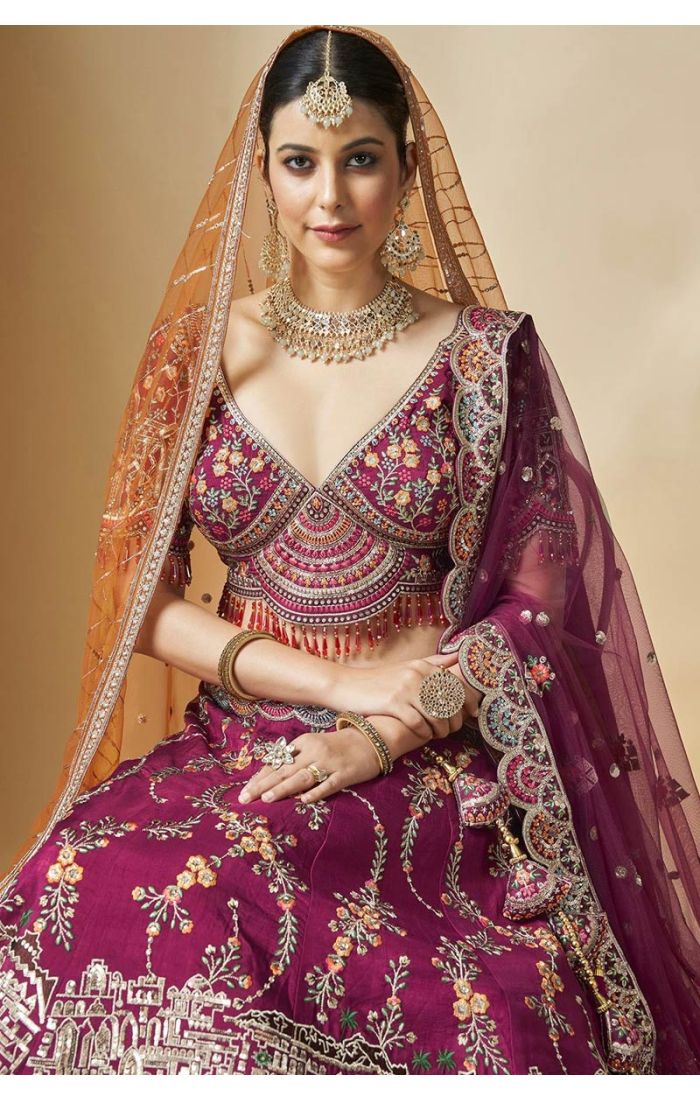 Seated bride in maroon silk heavy embroidered lehenga choli with V neck – LEHV4131