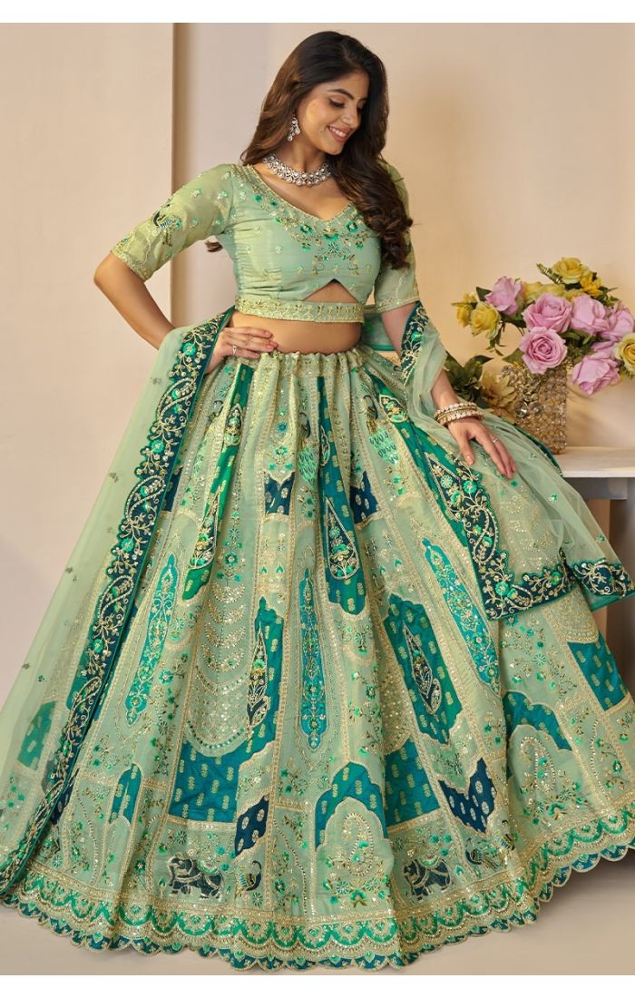 Twirling shot of mint green lehenga showcasing detailed zari and peacock patchwork.