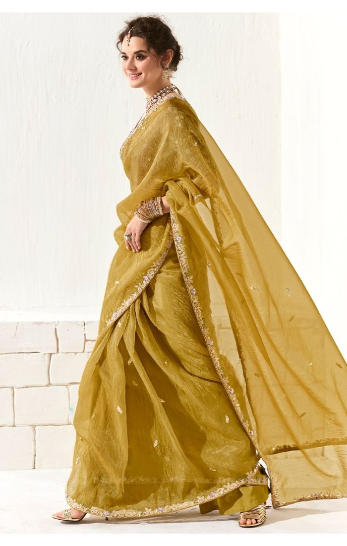 Side profile of mustard yellow organza tissue saree with lace border