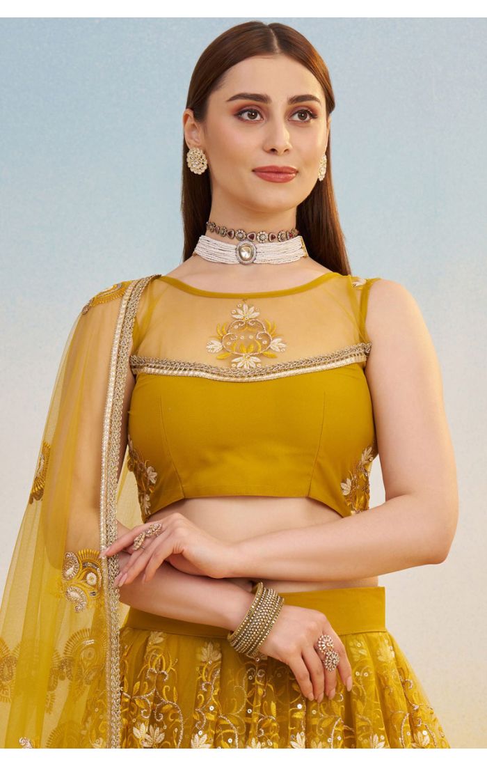 Close-up of mustard yellow net lehenga blouse with illusion neckline and detailed embroidery, luxury festive wear by Appelle Fashion.