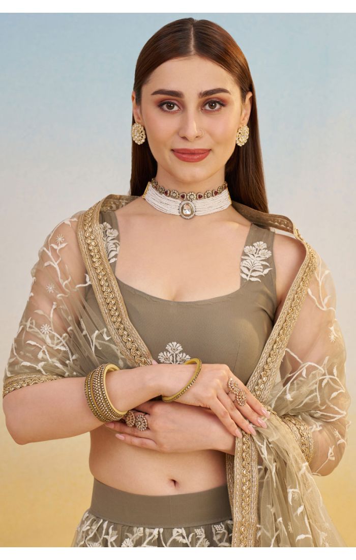 Close-up of olive green net lehenga blouse and dupatta with detailed floral embroidery, designer ethnic couture by Appelle Fashion.