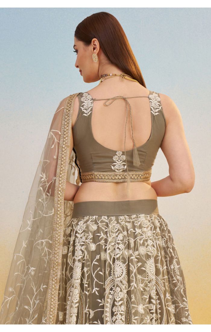 Flared skirt and border detailing of olive green embroidered net lehenga with intricate thread and zari work, luxury bridal and party wear.