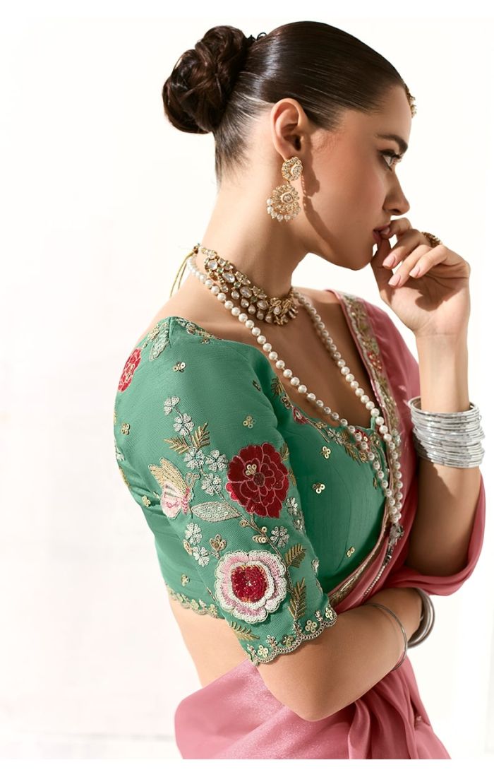 Side profile showcasing peach organza saree with intricate lace border and green floral blouse – wedding saree style