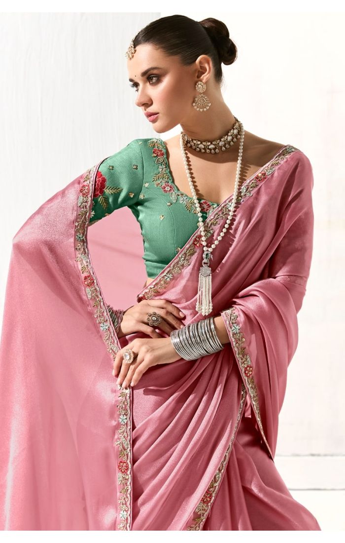 Close-up of green pure silk blouse with red floral embroidery paired with peach saree – luxury Indian saree