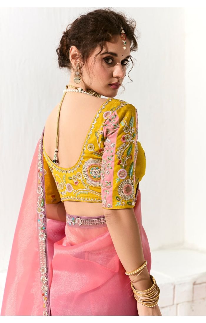 Backside view of yellow blouse with open-back cut and floral embroidery.