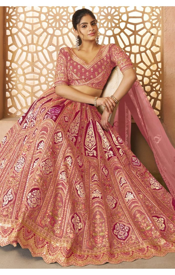 Bride seated wearing pink banarasi silk lehenga with intricate floral embroidery