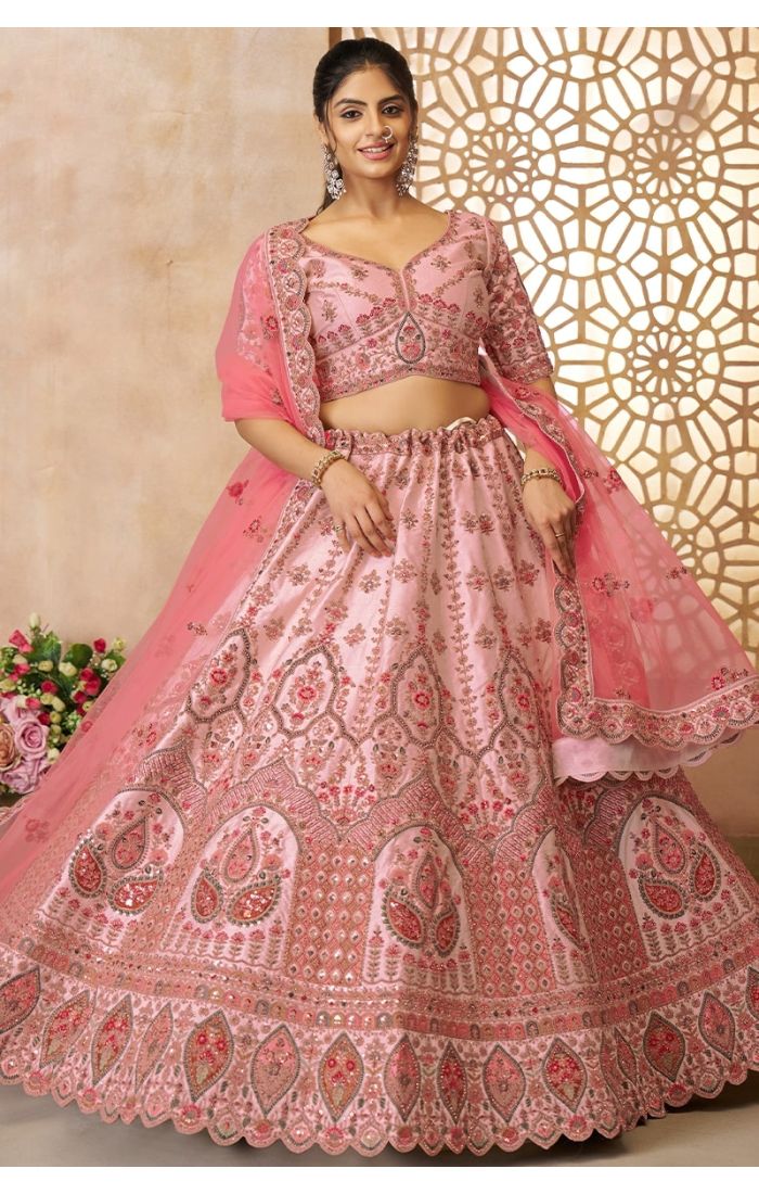 Model showcasing full flare of embroidered pink wedding lehenga in luxurious silk