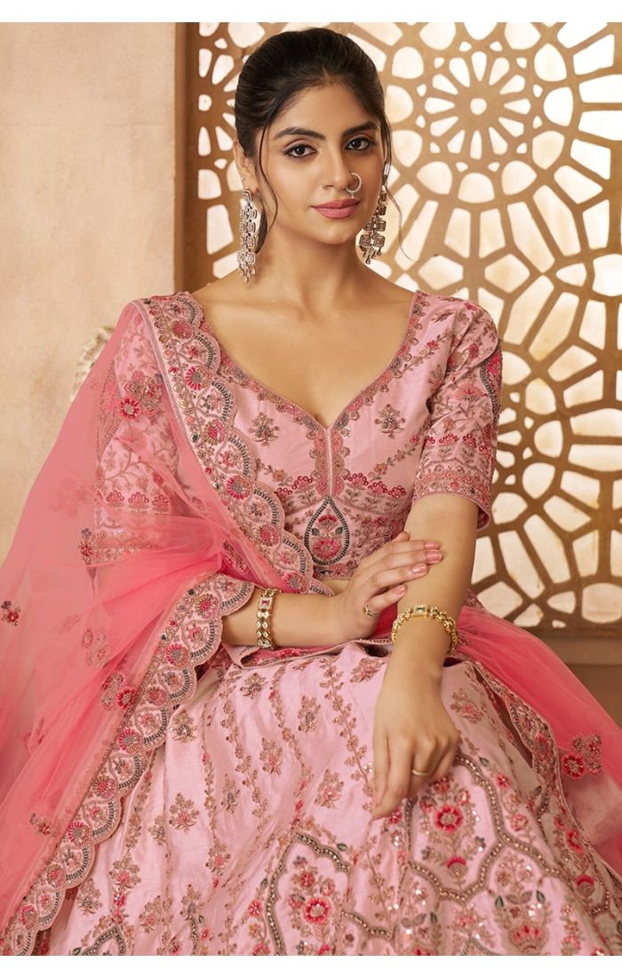 Seated pose in bridal pink lehenga choli with heavy embroidery for weddings