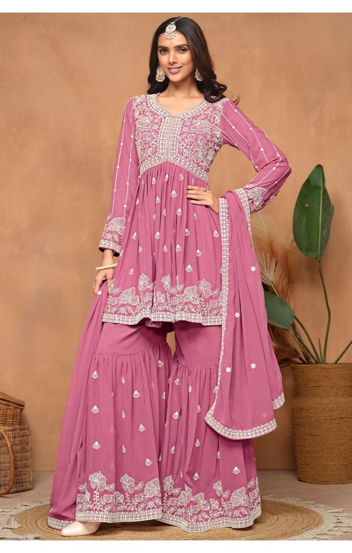 Front full view of pink faux georgette sharara suit with heavy embroidery and sequins.
