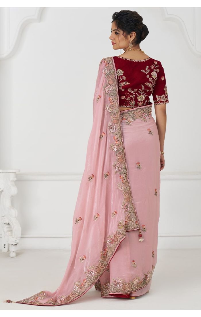 Back view of pink embroidered saree and contrast blouse with zari detail.