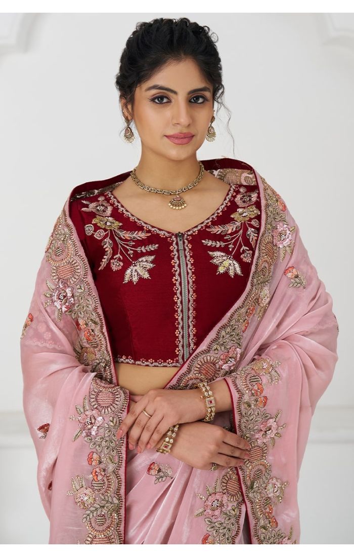  Close-up showing zari sequin embroidery on pink saree with maroon blouse detail.