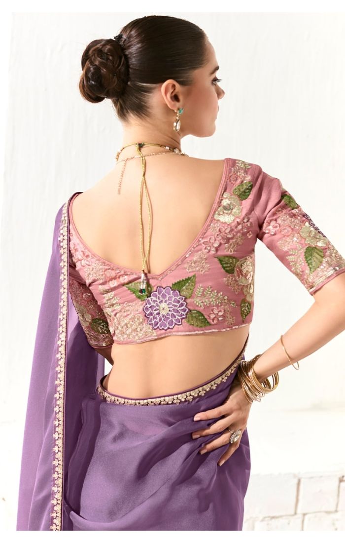 Back view showcasing embroidered pink silk blouse with detailed floral motifs and deep back cut.