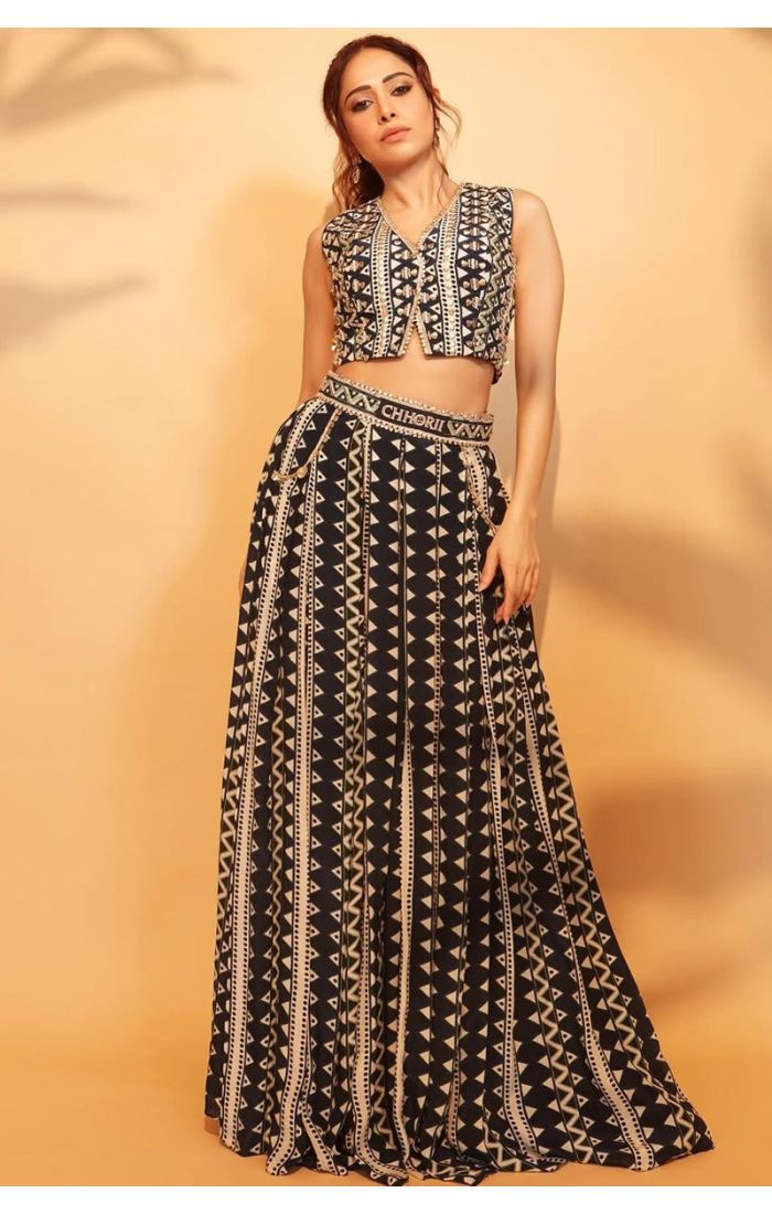 Woman wearing a black mirror work sleeveless crop top with tribal embroidery, styled with matching earrings.