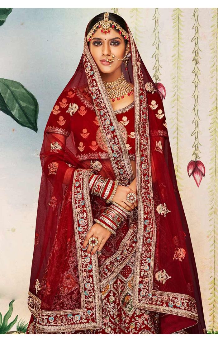 Close-up of red velvet bridal lehenga blouse with round neck and heavy embroidery, luxury Indian wedding couture by Appelle Fashion.