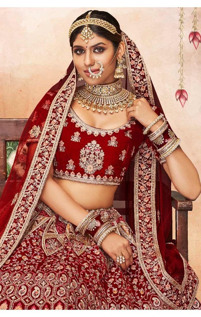 Close-up of red velvet bridal blouse with scoop neck and heavy embroidery, luxurious Indian bridal couture by Appelle Fashion.