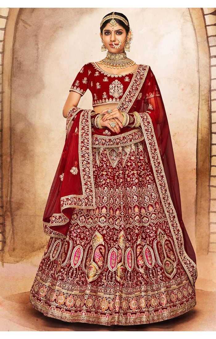 Full view of red velvet bridal lehenga with scoop neck blouse and intricate heavy embroidery, perfect for royal weddings.
