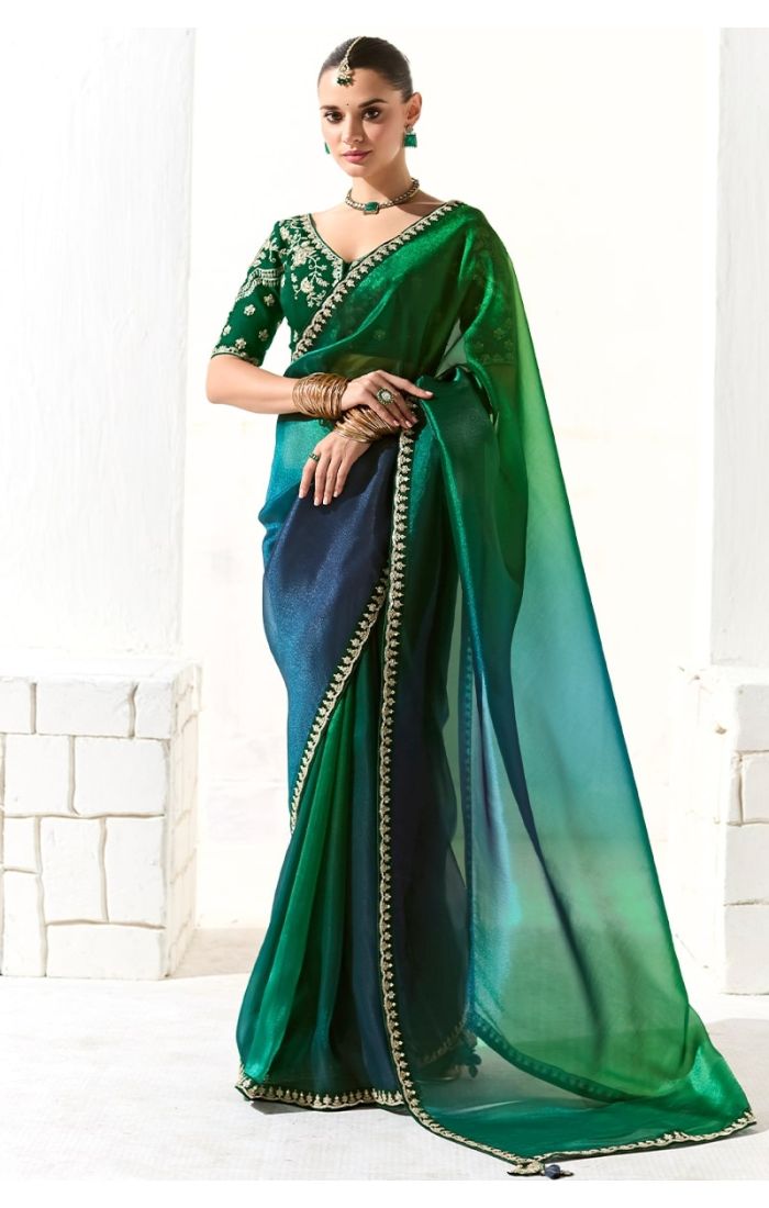 Front view of model in green-blue organza saree with embroidered blouse