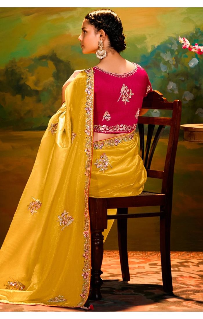 Back view of mustard saree highlighting embroidery and rama green blouse