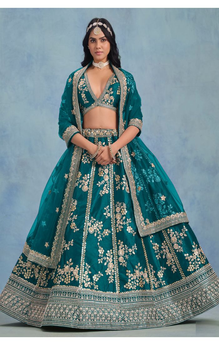 Side profile highlighting zari embroidery and net dupatta of teal lehenga – LEHV4096