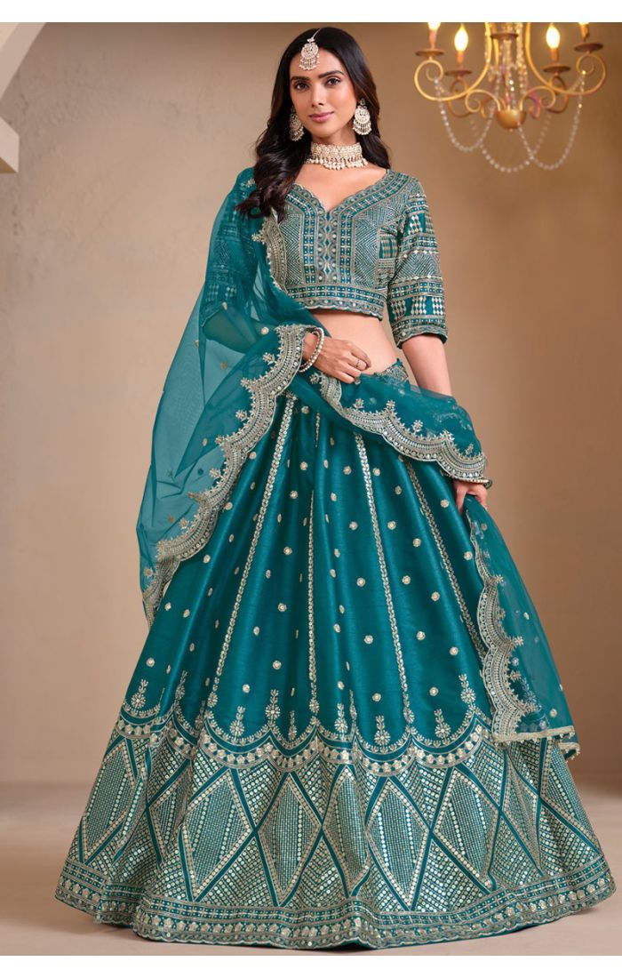 Model wearing teal mirror embroidered lehenga choli with net dupatta – full view