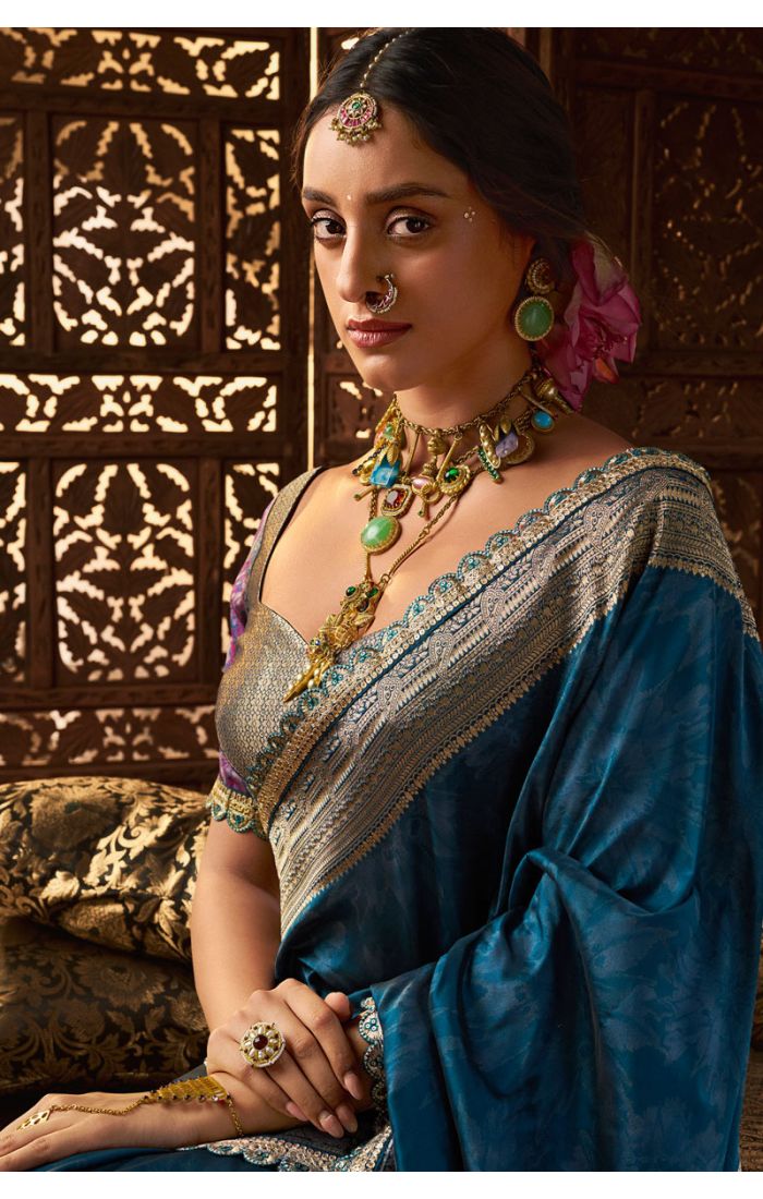 Elegant seated look showcasing teal silk party saree with gold blouse