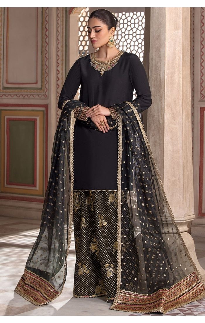 Side profile view of Black Silk Blend Salwar Suit featuring embroidered neckline and statement earrings for a festive look.