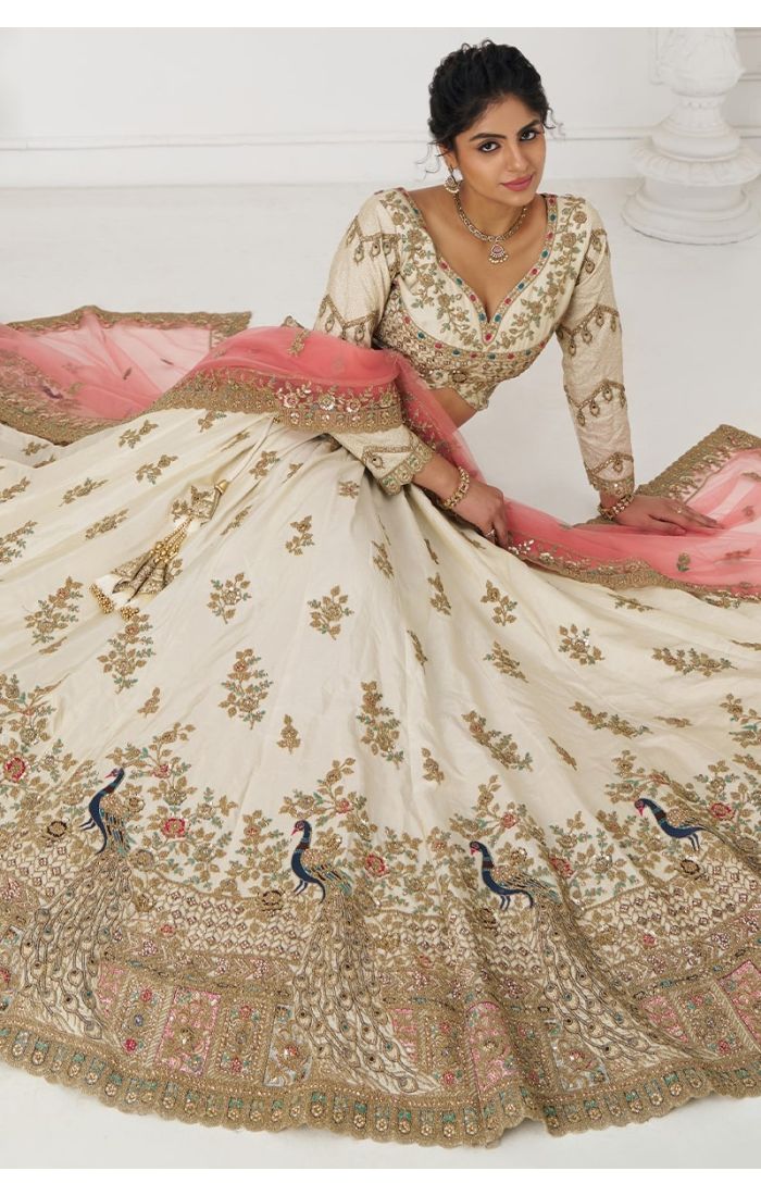 Bride wearing flared white lehenga with multicolor thread and zari peacock embroidery