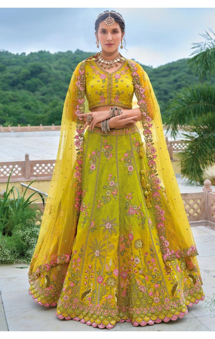 Yellow Embroidered Lehenga Choli with Pink Floral Motifs for Haldi Ceremony, paired with a delicate net dupatta, perfect for pre-wedding celebrations.